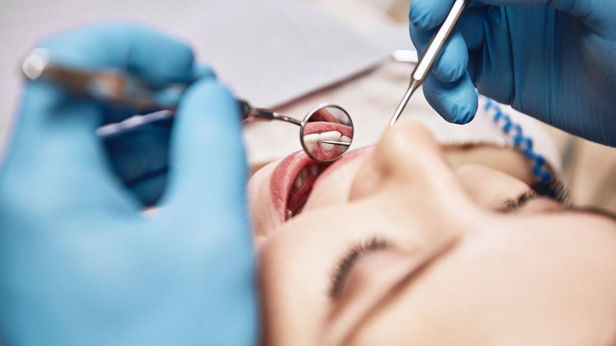 Advanced Medicine, Trusted Care. Attractive woman at the dental office. Dentist examining patient's teeth in clinic.